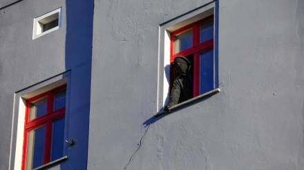 Un okupa enmascarado se asoma a la ventana de una viviendaUn okupa enmascarado se asoma a la ventana de una vivienda