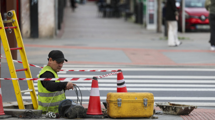 Un trabajador tira cable de telecomunicaciones en una calle de Bilbao
