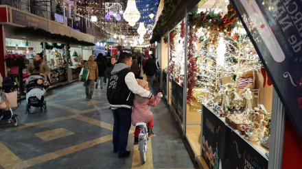 Un padre y su hija pasean por el mercado de Navidad de Lorca el día de su apertura