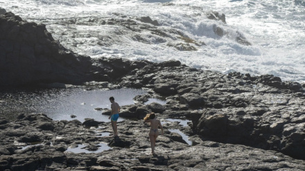 Dos jóvenes en la playa de Los Charcones, en Playa Blanca, en el municipio de Yaiza (Lanzarote). EFE | Adriel Perdomo
