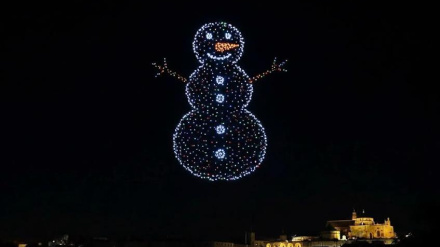 Drones en el cielo nocturno formando un muñeco de nieve y al fondo se ve iluminada la Mezquita-Catedral de Córdoba
