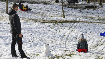 Niños junto a sus padres disfrutan con un trineo de la nieve en el alto de Urkiola, en Bizkaia