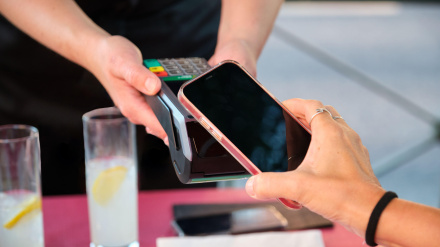 Una mujer paga con su teléfono móvil en un restaurante