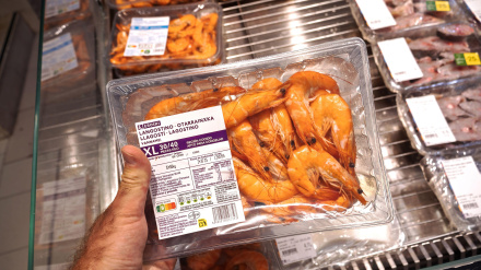 Una mano sostiene un paquete de langostinos XL en la sección de mariscos de un supermercado en Palma, Mallorca.