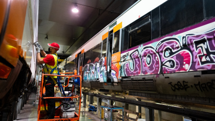 Un operario limpia los grafitis de un tren de Rodalies