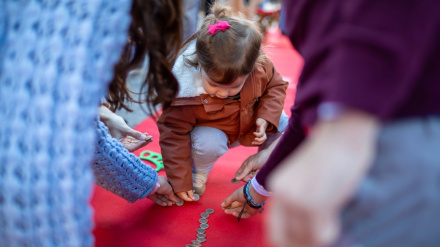 Una niña coloca una moneda en la Carrera por el Euro de 2024