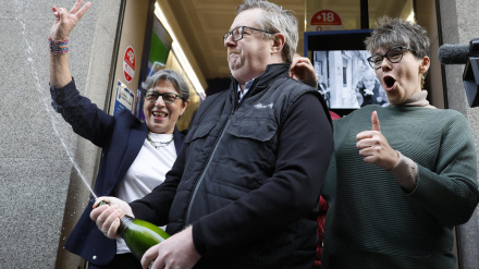 Personas celebran a las puertas de la administración de loterías de la calle Barquillo, en Madrid