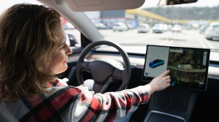 Mujer tocando la pantalla del coche.
