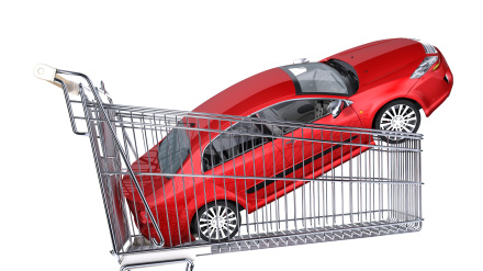 Carrito de supermercado con un coche rojo en su interior.