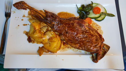 Pierna de cordero lechal, ensalada, patatas laminadas, servida en plato cuadrado en la terraza del restaurante Palomeque, Zaragoza