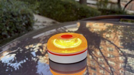 Baliza V16 encendida encima de un vehículo