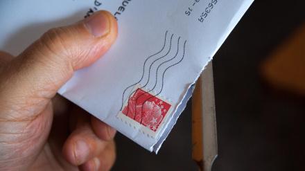 Un hombre abre una carta postal