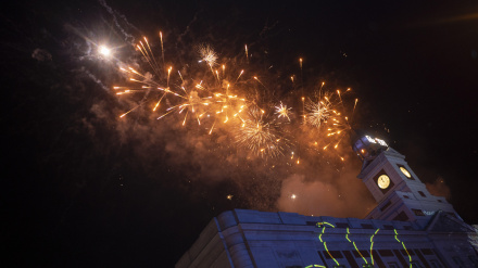 Fuegos artificiales en el cielo durante el Año Nuevo. Cientos de personas se reunen en la Puerta del Sol de Madrid para dar la bienvenida al año nuevo.