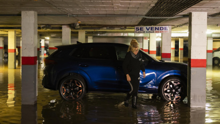 Una mujer camina por un garaje inundado en la Estación de Cártama después de los problemas sufridos anoche por la crecida del río