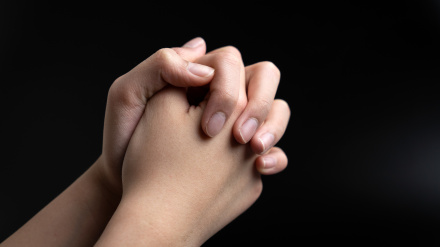 Manos de una persona rezando