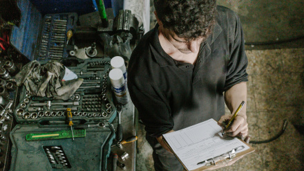 Técnico revisando documentación en un taller mercánico de servicio de automóviles