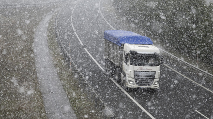 Un camión circula este viernes bajo una nevada por la A-67