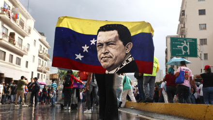 Un simpatizante del oficialismo sostiene una bandera con la imagen del fallecido presidente de Venezuela, Hugo Chávez