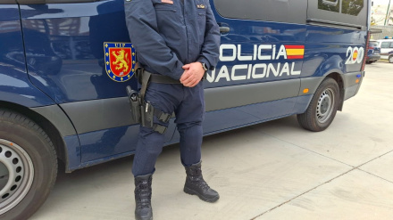 Un coche y un agente de la Policía Nacional.