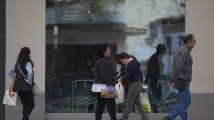 Algunas personas sin mascarilla guardan cola en un supermercado