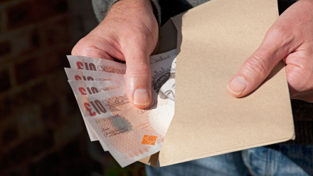 Un hombre cuenta billetes en libras británicas