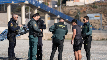 Agentes de la Guardia Civil española detienen a un joven marroquí que intentaba cruzar a nado la frontera de El Tarajal en Ceuta