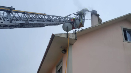 Los bomberos actuando en la extinción por la chimenea