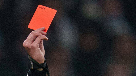 Detalle de un árbitro mostrando una tarjeta roja durante un partido de fútbol