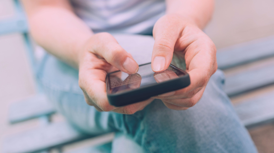 Concepto de miedo a perderse algo (FOMO), primer plano de manos femeninas usando un teléfono inteligente móvil, enfoque selectivo
