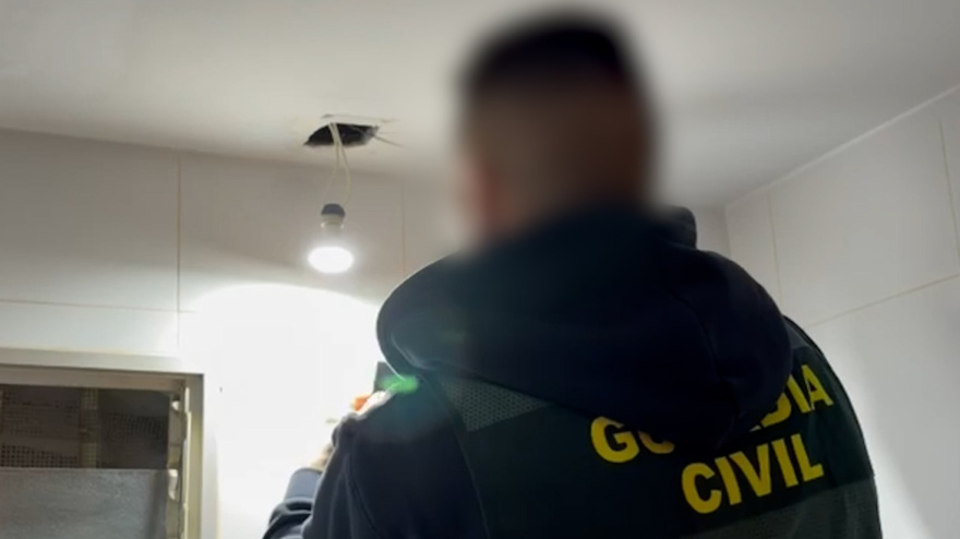 Agente desmontando la cámara espía