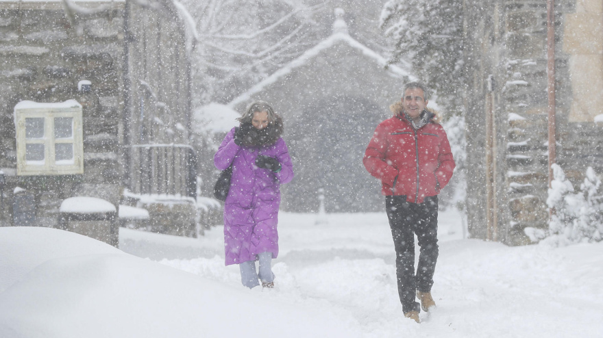 Personas caminan en el municipio lucense de Pedrafita do Cebreiro durante una fuerte nevada
