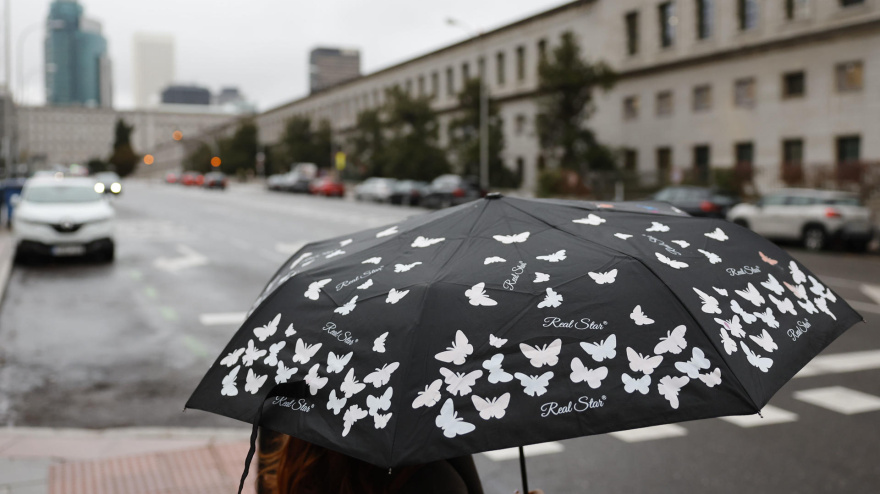 Una mujer se protege de la lluvia