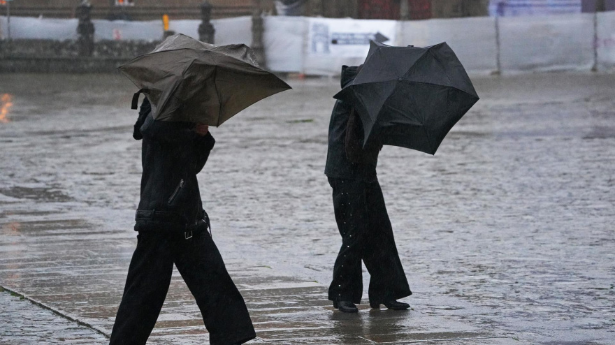 Varias personas intentan sujetar sus paraguas en una imagen de archivo