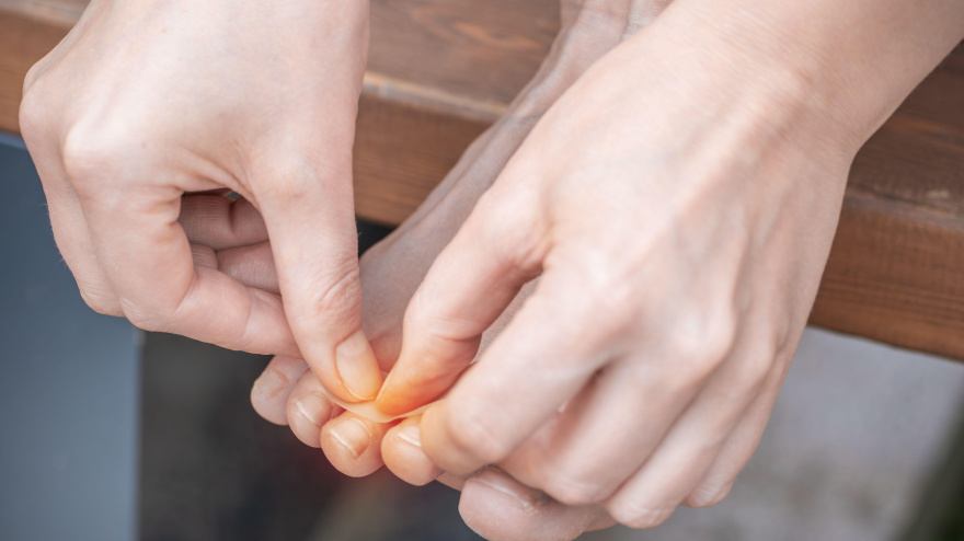 Una persona tratando uñas encarnadas con la mano. Enfoque en el autocuidado, la salud y la higiene personal.