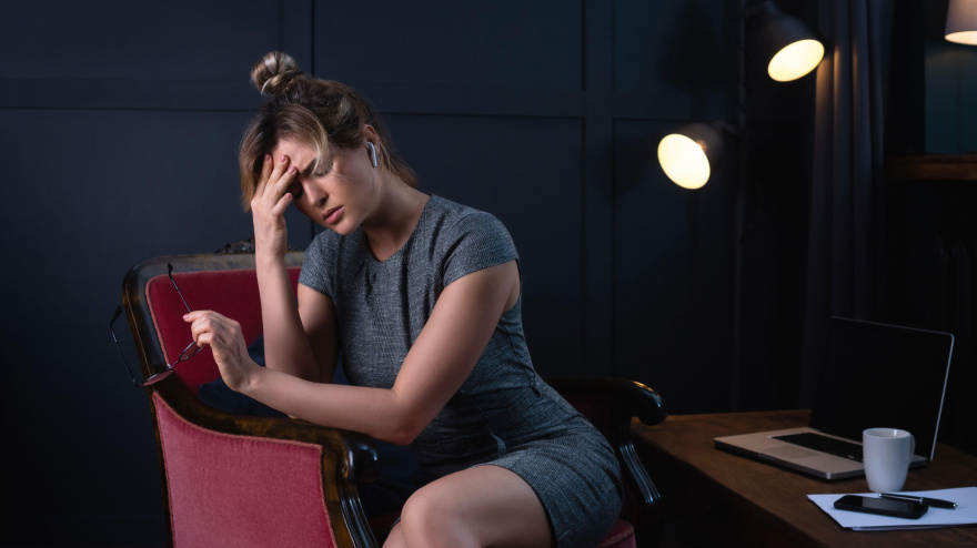 Mujer de negocios cansada con dolor de cabeza durante el trabajo nocturno en la oficina. Concepto de baja laboral