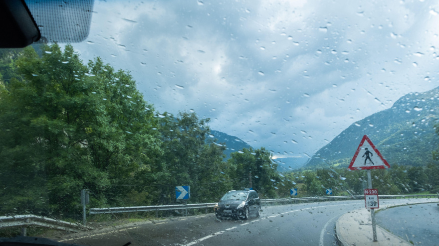 Una carretera mojada en un día nublado y lluvioso vista desde el interior de un vehículo