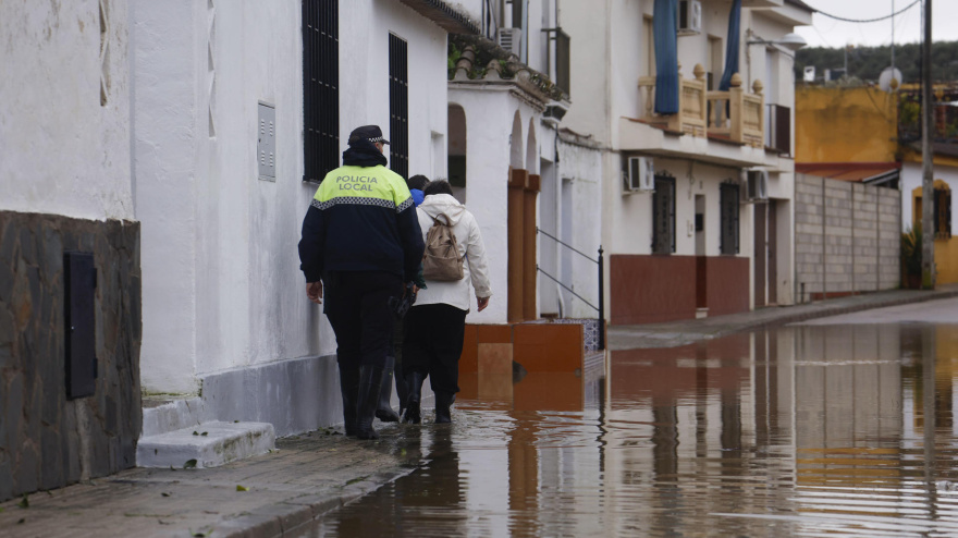 Vecinos de la barriada de Alcolea observan la subida del río que adentrado en sus calles y han tenido que ser desalojados