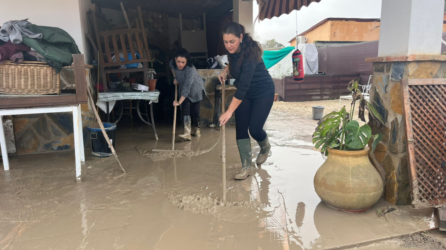 Una vecina limpiando su casa de barro