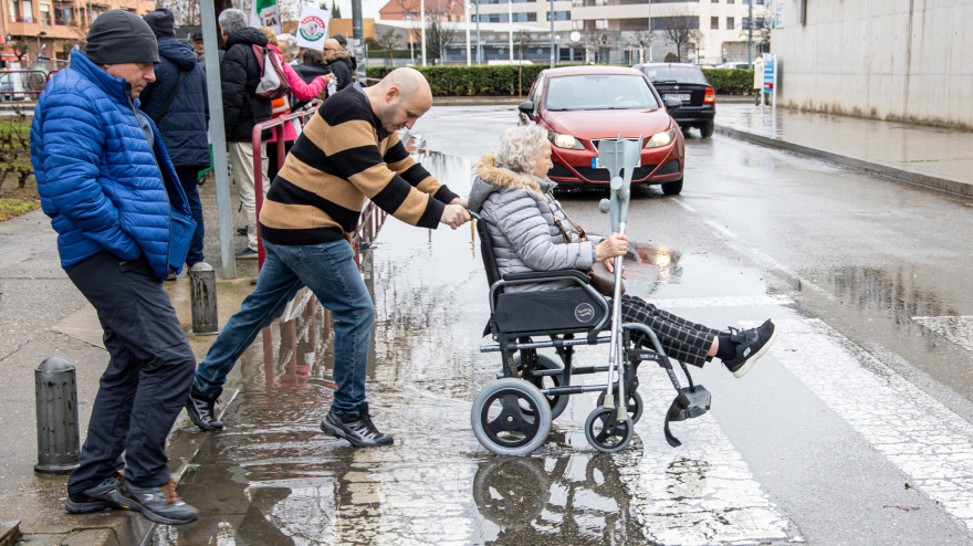 Dos personas intentan avanzar en una calle encharcada como consecuencia de la lluvia caída en Logroño