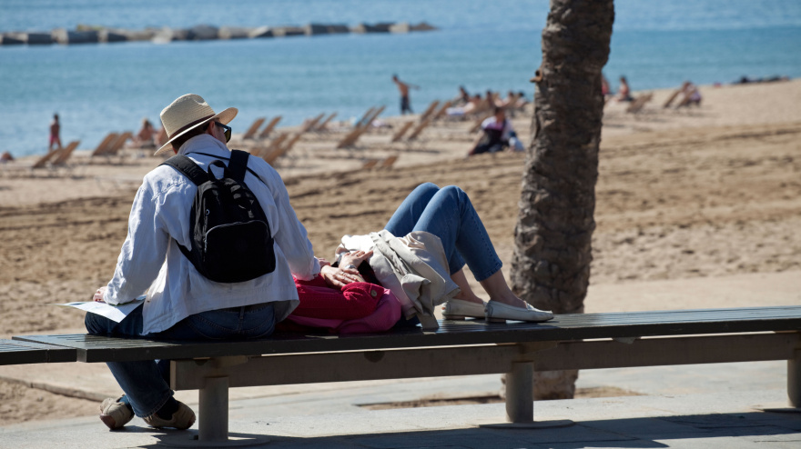 Una pareja descansa en un banco, en Barcelona