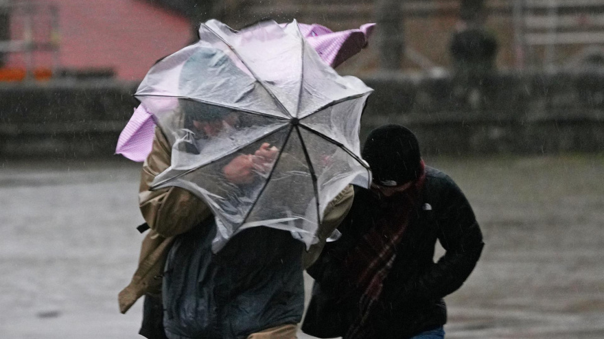 Varias personas intentan sujetar sus paraguas en una imagen de archivo