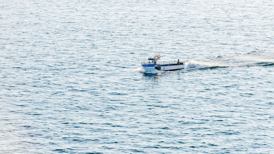 Un barco pesquero navega por la Ría de Pontevedra de regreso desde las islas exteriores en un día nublado de verano.
