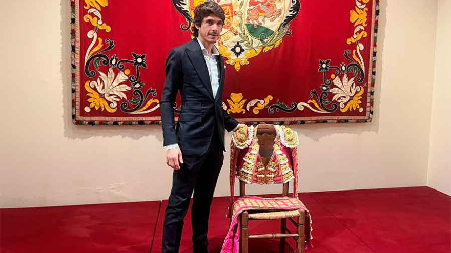 Sebastián Castella posando junto al traje de luces donado a la Maestranza