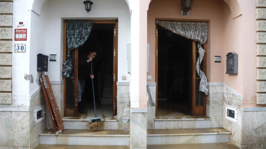 Vecinos de la barriada de Los Cardiales en Cártama limpian el barro en sus casas tras las intensas lluvias.