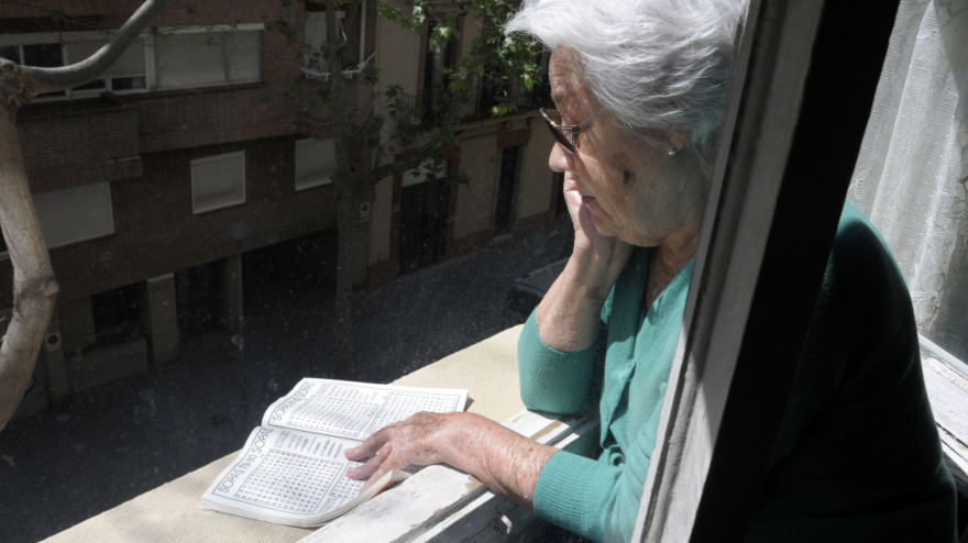 Una jubilada leyendo en el balcón de su casa en Barcelona