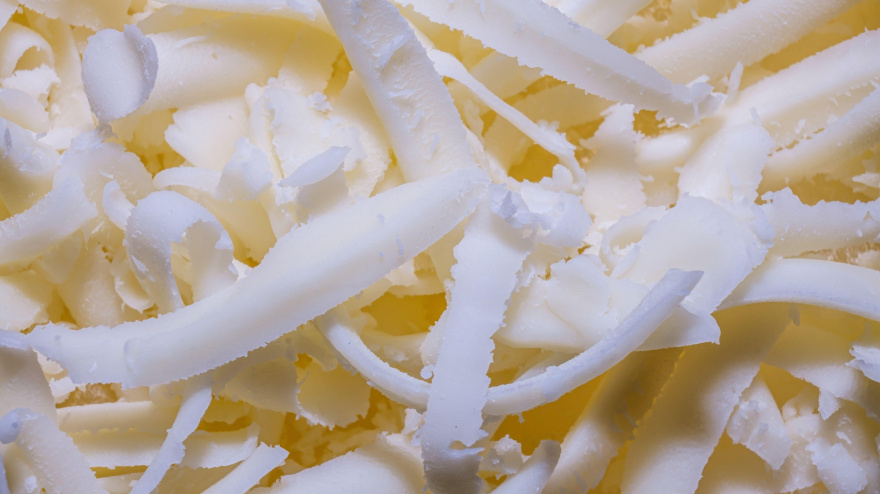 Primer plano de queso mozzarella rallado que muestra la textura del alimento