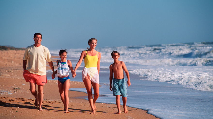 Familia paseando por la playa