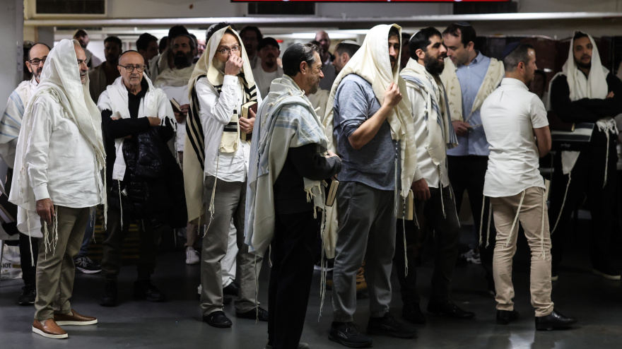 La gente reza mientras se refugia en un estacionamiento subterráneo luego de las alarmas por misiles provenientes de Irán.