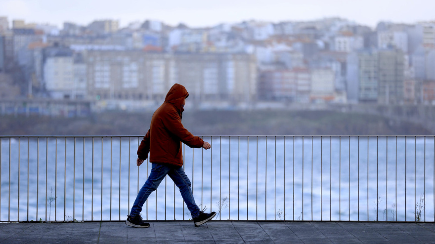 Un hombre camina por el paseo marítimo de A Coruña, fotografía recurso