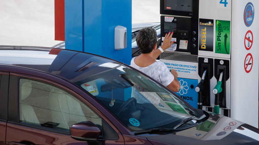 Una mujer antes de echar carburante a su vehículo en una estación de servicio.